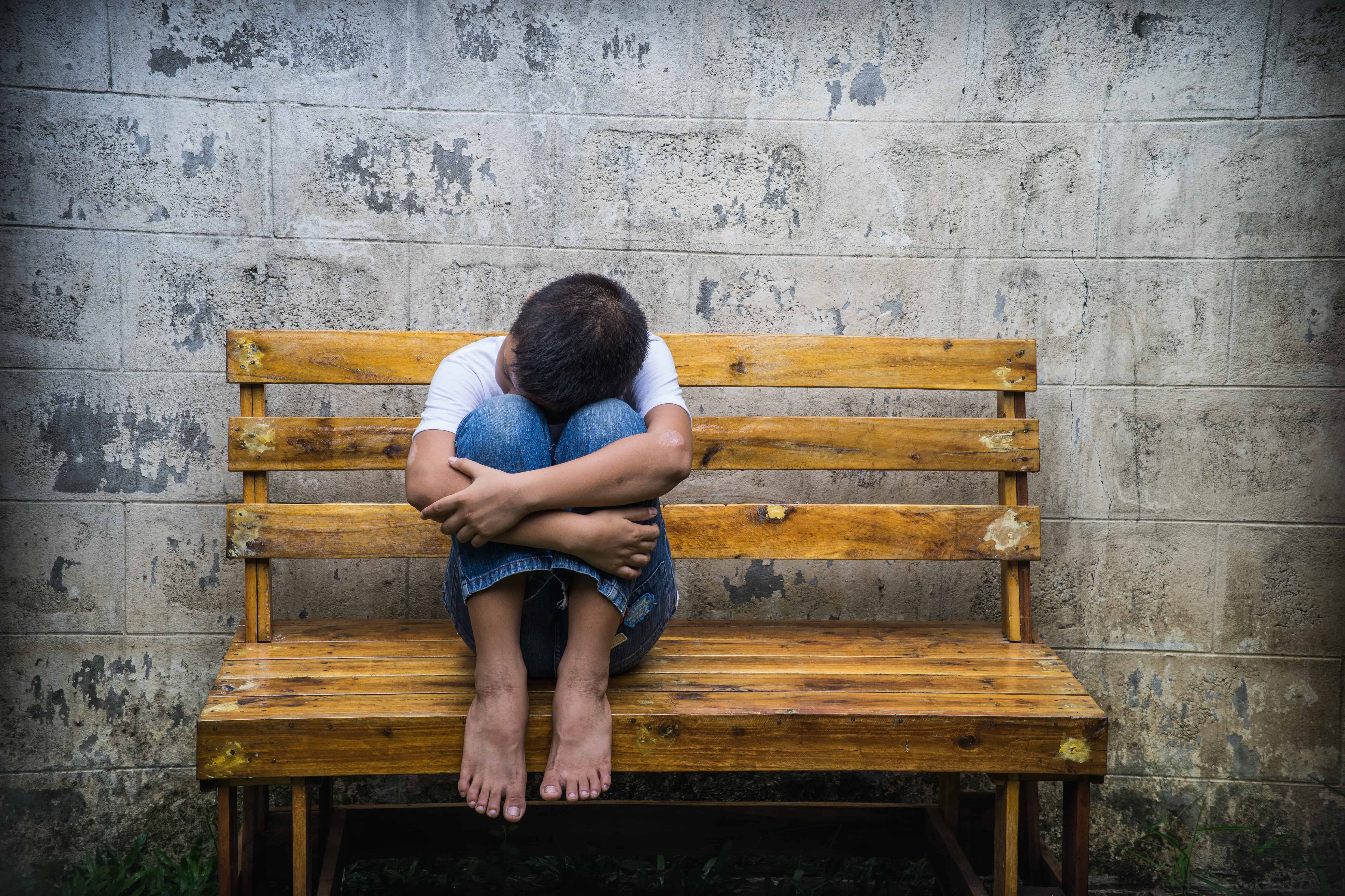 Young Asian homeless boy scared and alone, he is at high risk of being physically abused and trafficked.